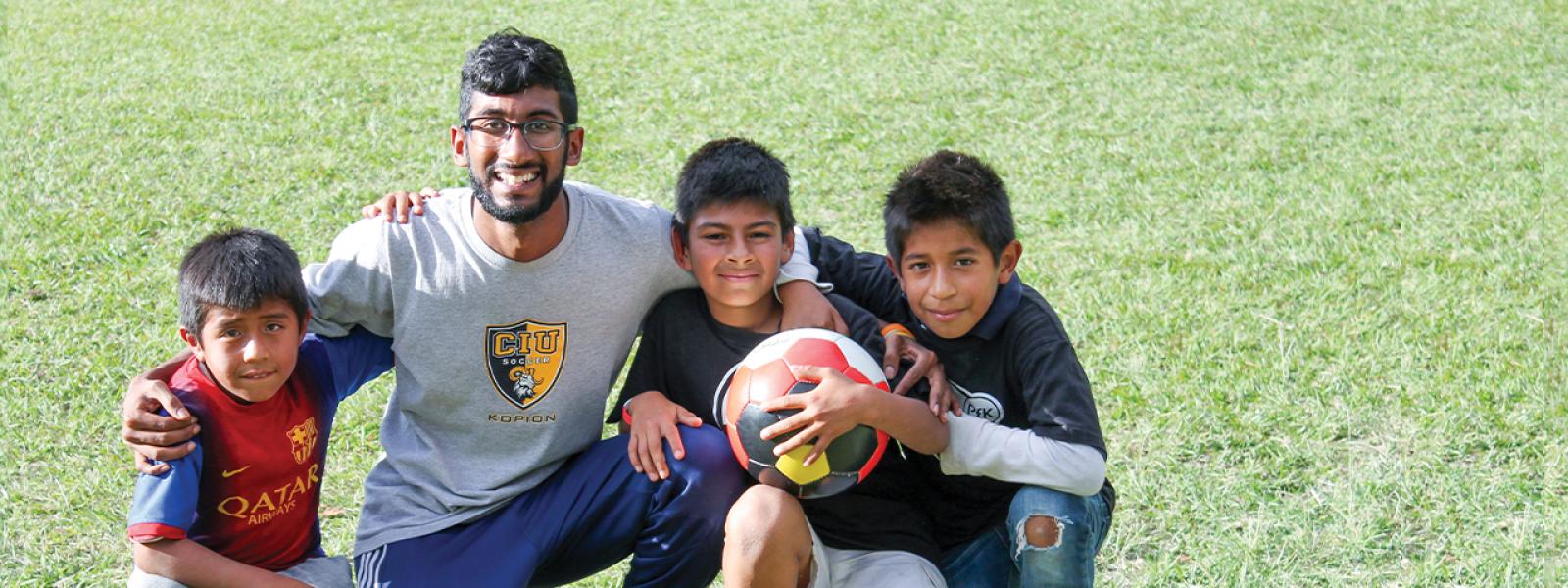 CIU soccer player playing with children.